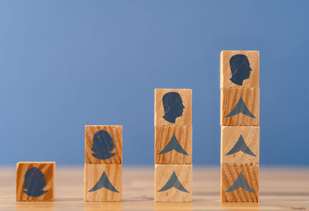 Close up photo of rising wooden blocks with woman and man head silhouette. Concept of gender...