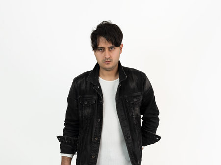 Closeup studio photo of brown skinned young adult model wearing black jacket with messy hairstyle. Concept of fashion and stylish clothing.の写真素材
