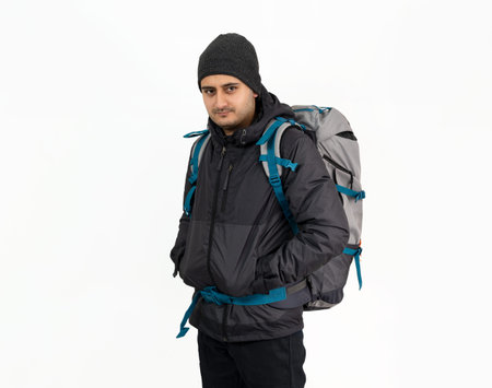 Studio photo of Brown skinned young backpacker, camper or hiker standing on isolated background....