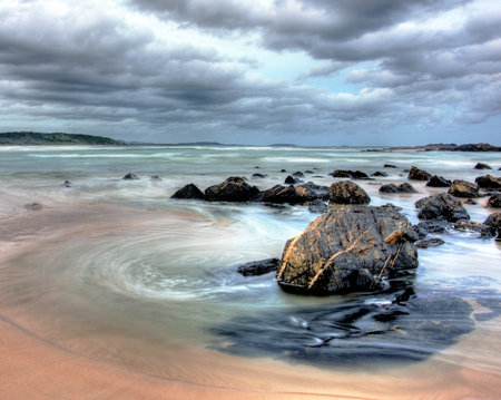 beach at dusk with clouds in the skyの写真素材