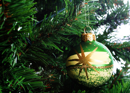 Glass Christmas decoration on a green treeの写真素材