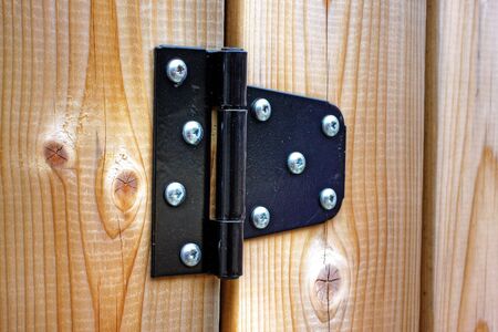 metal hinge on polished wooden doorの写真素材