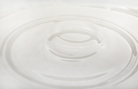 drop of milk falling into a bowlの写真素材