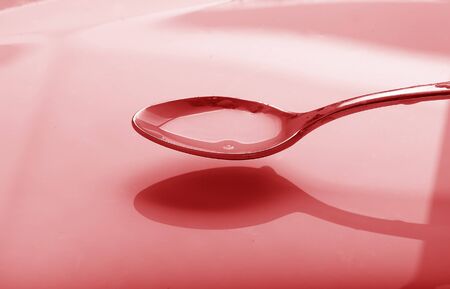 a spoon full of syrup over a bowlの写真素材