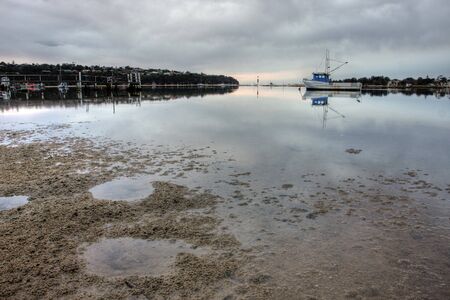 boat lying on the side at low tideの写真素材