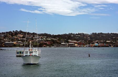 boat resting inside the harbor at low tideの写真素材