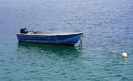 boat resting inside the harbor at low tideの写真素材