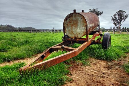 Rusty oil drum wagon on grassの写真素材