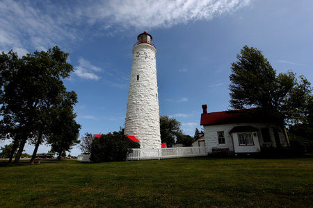 Canadian lighthouse against blue sky with cloud coverの写真素材