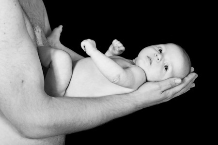 loving father holding infant daughter tenderlyの写真素材