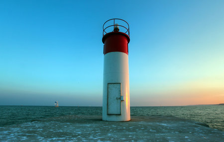 Canadian lighthouse against blue sky with cloud coverの写真素材