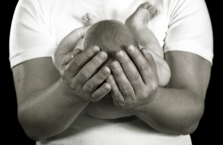 loving father holding infant daughter tenderlyの写真素材