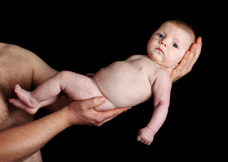 adult man tenderly holding a young babyの写真素材