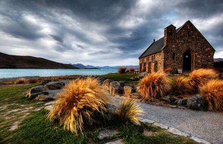 quiet church by a glacier lake against a mountain backdropの写真素材