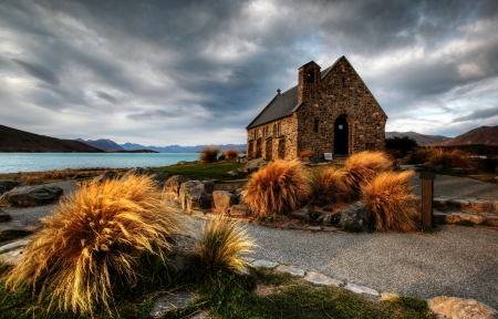 quiet church by a glacier lake against a mountain backdropの写真素材