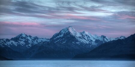 calm waters of a glacier lake with mountains behind の写真素材