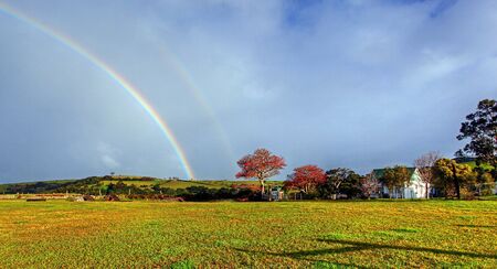 rainbow over a farm fieldの写真素材