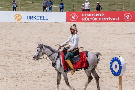 Unidentified medieval archer in costumes of ancient Turkish troops and Ottoman Empire soldiers is aiming with arrow and curve at a target on a horse. ISTANBUL,TURKEY,May 13,2017のeditorial素材
