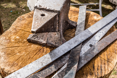 Anvil and iron plates on a wooden tableの写真素材