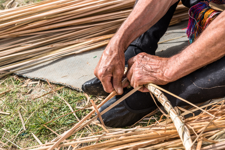 Unidentified man makes a traditional wicker basket.の写真素材