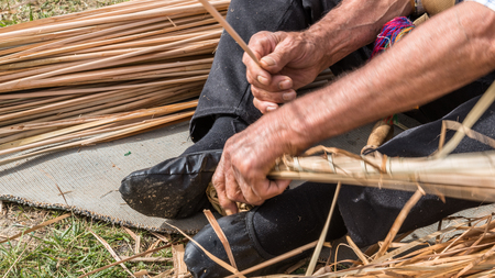 Unidentified man makes a traditional wicker basket.の写真素材