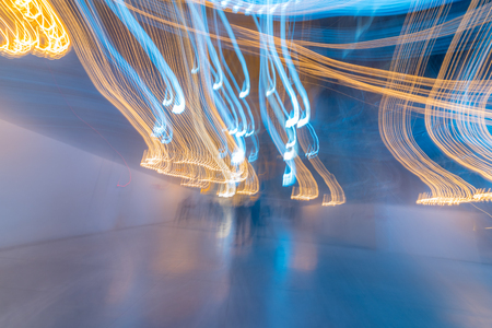 Multicolor abstract soft light painting of background of light trails with circular rotation in a building by long exposureの写真素材