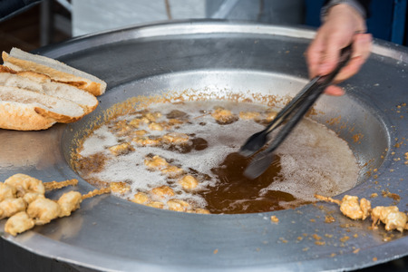 Turkish style chopped mussels (Midye tava) fried in deep oil  in a special pan on the Street in Istanbul, Turkey.の写真素材