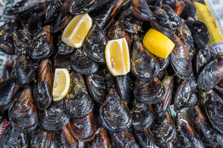 Turkish style appetizer street food stuffed mussels called midye dolma on bench for sale with lemon which is served with a squirt of lemon juice in Istanbul-Turkeyの写真素材