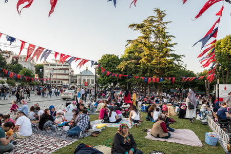 Muslim people who are fasting wait for the adhan (ezan) and evening meal (Iftar) in Ramadan month in Sultan Ahmet Park, Istanbul,Turkey.ISTANBUL,TURKEY,JUNE 11,2017のeditorial素材