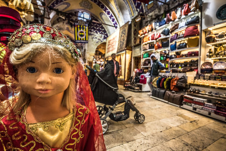 Unidentified Tourists visiting and shopping in the Grand Bazaar in Istanbul.Interior of the Grand Bazaar with doll in traditional Turkish clothes on the foreground.Istanbul, Turkey.April 17, 2017のeditorial素材