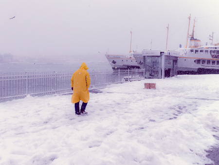 Unidentified man walking near Karakoy pier on a snowy day in winter.Istanbul,Turkey,07 January 2017の写真素材