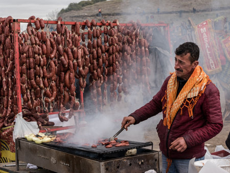 Unidentified man selling salami made of camel meat in Selcuk camel wrestling arena.Izmir,Turkey.January 16, 2017のeditorial素材