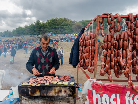 Unidentified man selling salami made of camel meat in Selcuk camel wrestling arena.Izmir,Turkey.January 16, 2017のeditorial素材