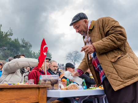 Unidentified Turkish people eating and watching camel wrestling in arena.Camel wrestling is popular tourist attraction in Selcuk,Turkey,January 16, 2017のeditorial素材