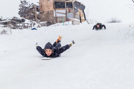Children slide on snow in old school style with hardwood sled in Istanbul.Happiness and joy concept.Istanbul,Turkey.31 December,2015のeditorial素材