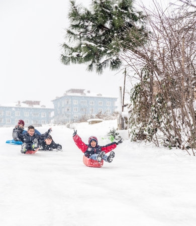 Children slide on snow in old school style with plastic box in Istanbul.Happiness and joy concept.Istanbul,Turkey.31 December,2015のeditorial素材