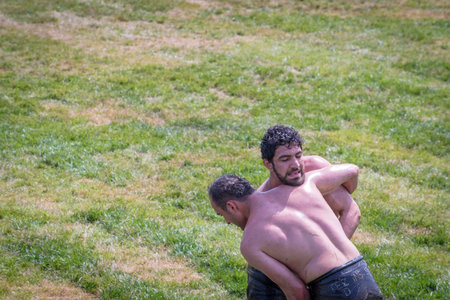 Unidentified Turkish people perform oil wrestling.Oil wrestling or grease wrestling (Yagli Gures) is...