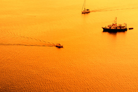 Sunset over the sea with sailing silhouette of boat or ship  on Sibenik coast ,Croatia