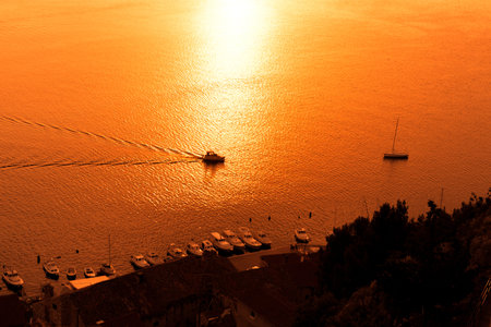 Sunset over the sea with sailing silhouette of boat or ship  on Sibenik coast ,Croatiaの写真素材