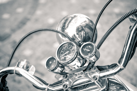 Close up of classic motorcycle shinny handlebar and chrome motorcycle speedometer on a street.の写真素材