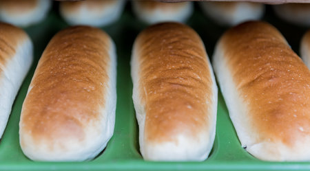 Shelves with fresh baked white wheat bread at bakery display for sale.