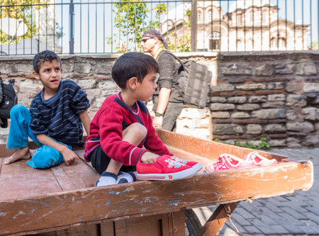 Unidentified small children transporting on wooden wheel car of junkman.Istanbul,Turkey.15 October,2017のeditorial素材