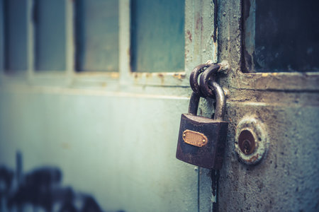 Architectural detail of a vintage, rustic metal door and lock 