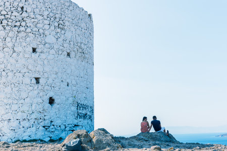 People sit near Traditional restored windmills on top of Bodrum hill overlooking Bodrum and Gumbet.23 August 2017.のeditorial素材
