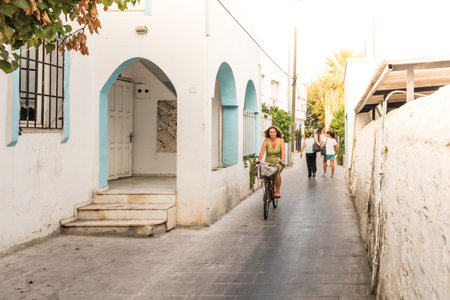 Unidentified woman rides a bike at old narrow streets of Bodrum,Turkey.23 August 2017.のeditorial素材
