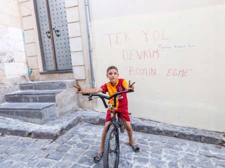 Unidentified child rides a bike at the traditional old stone street of Gaziantep city.Gaziantep.Turkey.03 September 2016のeditorial素材