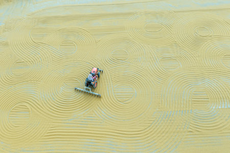 Worker spreads bulgur wheat on a field with conventional techniques for drying under the sun in Gaziantep,Turkey.03 September 2016のeditorial素材