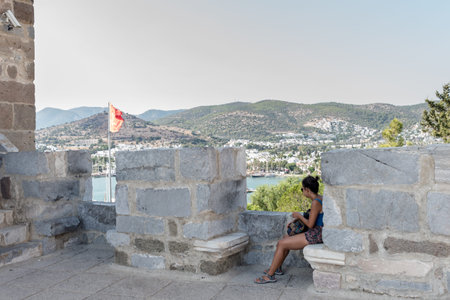 Unidentified woman rests at Castle of St. Peter or Bodrum Castle, Turkey.23 August 2017のeditorial素材