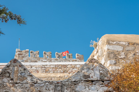 Exterior view of Castle of St. Peter (Bodrum Castle) and Turkish flag hanging  in a Bodrum,Turkeyの写真素材