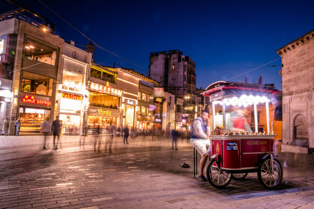 Long exposure or slow shutter speed and blurred image:Unidentified man sells grilled chestnut at Istiklal street,popular destination in Istanbul,Turkey.29 April 2018のeditorial素材